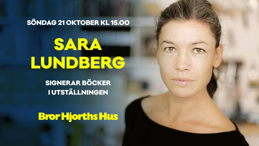 Sara Lundberg signerar böcker i utställningen.